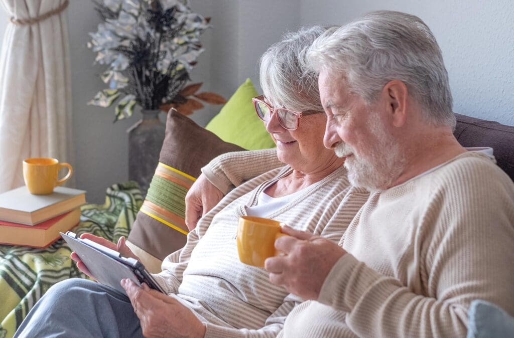 Smiling older couple relaxing at home on a couch