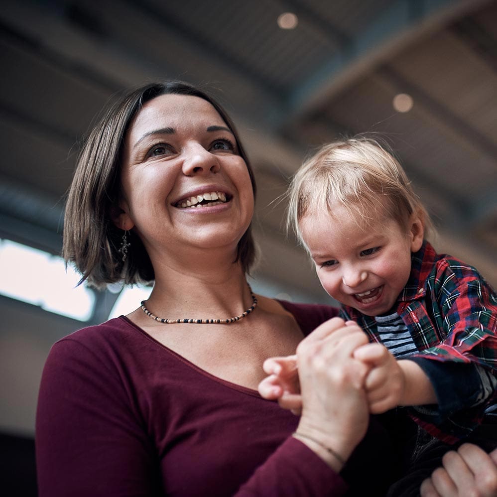 Young mother playing with her small son indoors, parenting moment